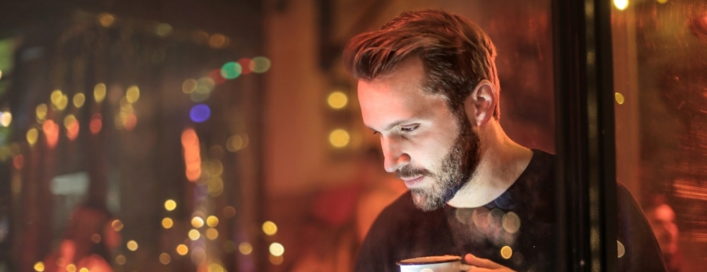 Hombre joven en un bar trabajando con su PC